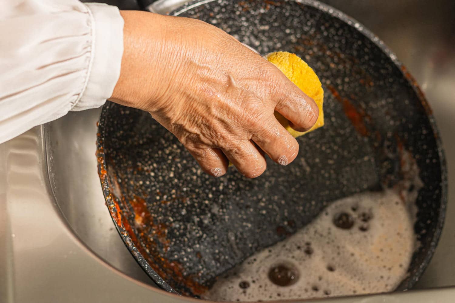 Learn how to clean a burnt pan and remove built-up grease step by step. Discover effective methods to restore pans and prevent permanent damage.